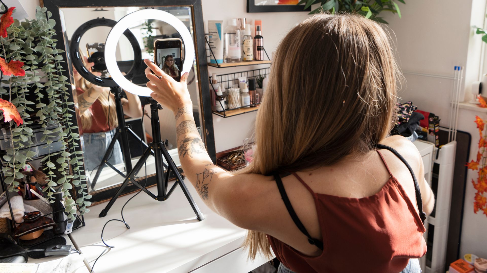 Woman creating content with ring light and smartphone in home setup