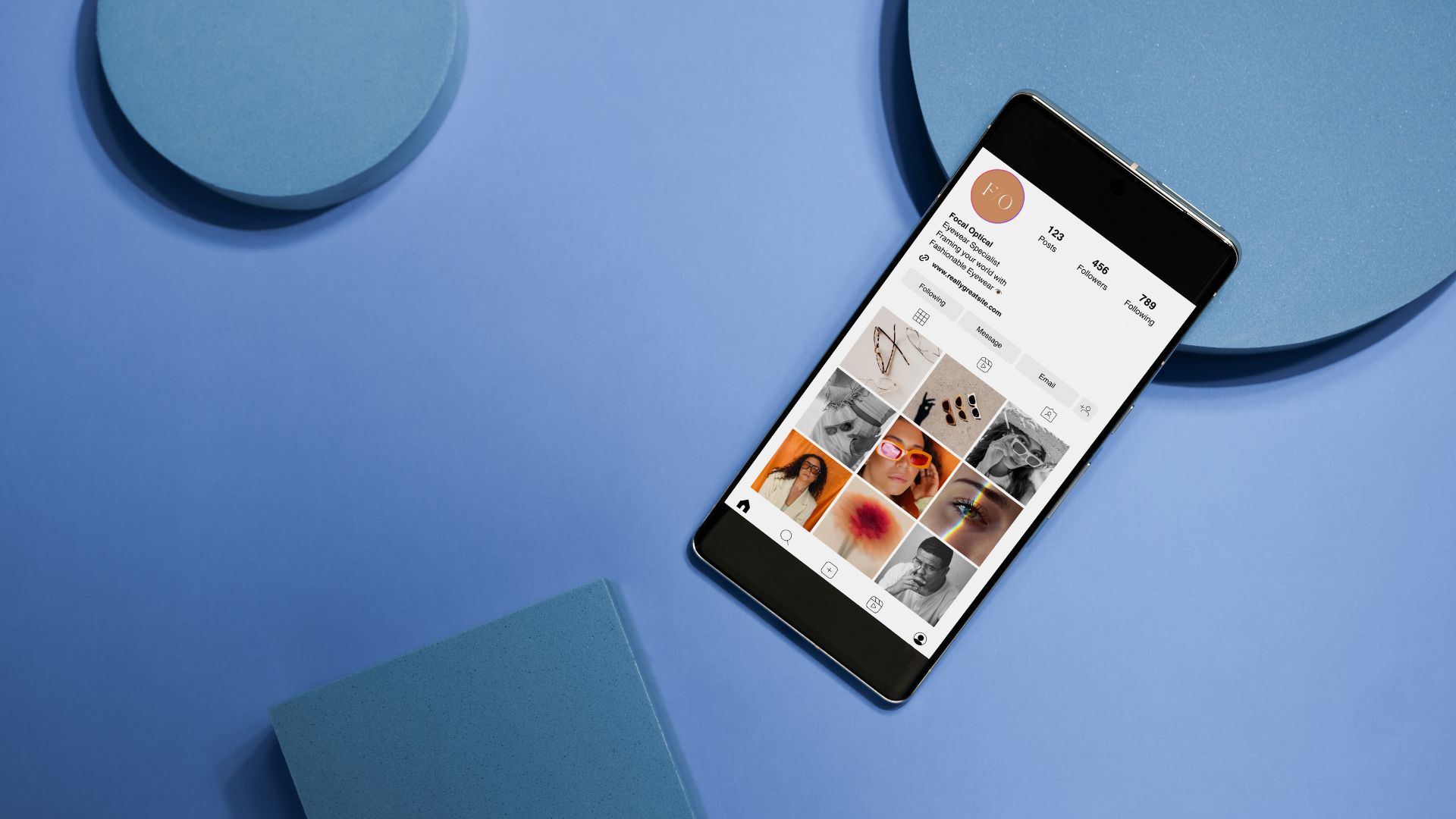 Smartphone displaying social media profile on blue geometric background