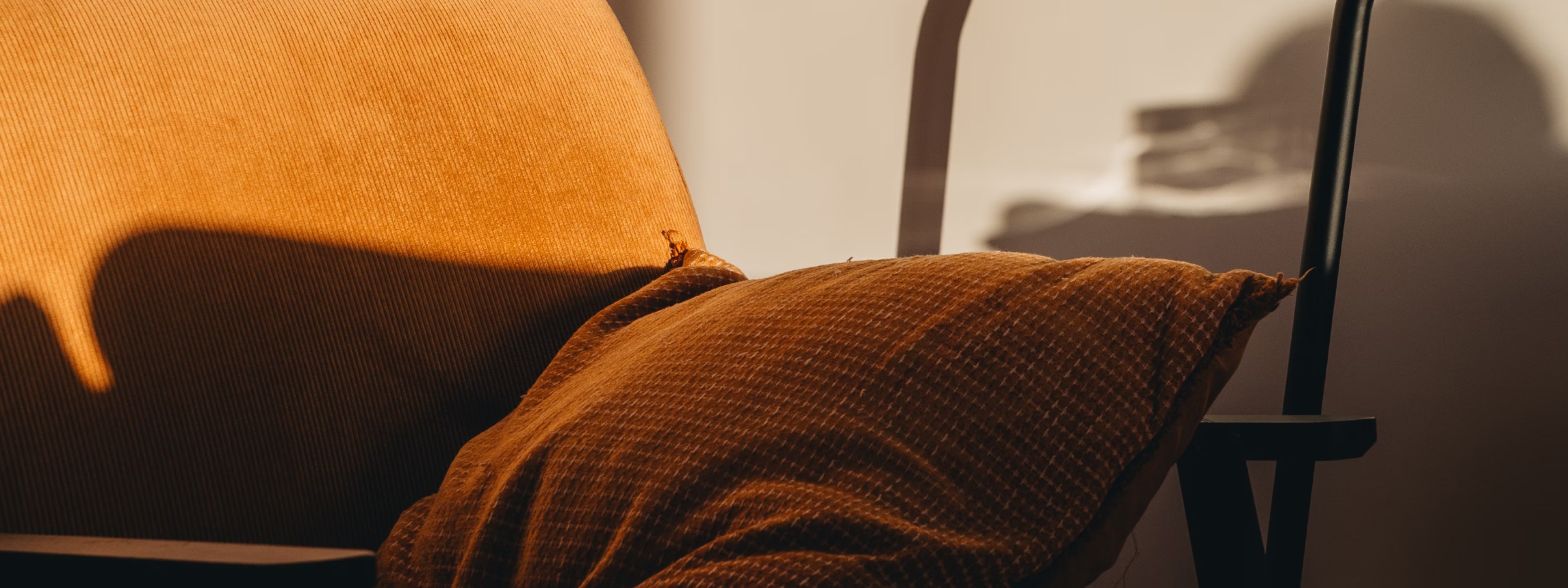 Warm orange and brown textured fabric draped over modern chair